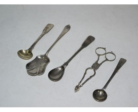 A pair of white metal sugar tongs; a silver sugar trowel; and three salt spoons.