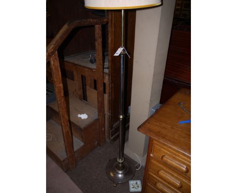 A polished steel and brass 19th Century lamp standard converted to electricity, fitted a modern cream shade..
