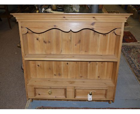 A reproduction Victorian style pine wall shelf unit, with flared cornice and panel back, fitted two shallow drawers in the ba