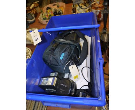 A Panasonic digital video camera; and a box of photographic equipment, including: flashes; light meters; etc.