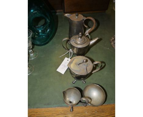 A late 19th Century four-piece bachelor's plated tea service; and a plated water jug with insulated handle and hinged cover.