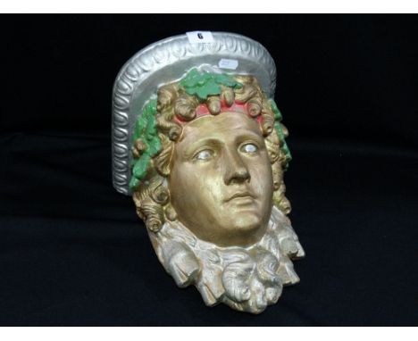 A Painted Plasterwork Wall Bracket Modeled As A Mask