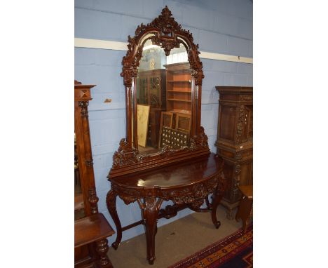 Heavily carved mahogany hall stand, probably Colonial, circa late 19th century, with mirrored back raised over a console tabl