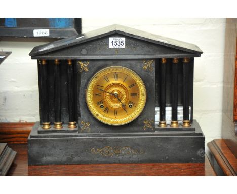 A slate mantel clock decorated with Corinthian column supports.