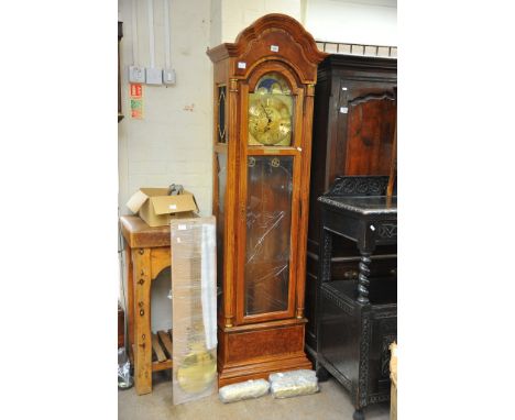 A Howard Miller light oak longcase clock with brass moon and stars dial, Complete with pendulum, weights key and booklet. One