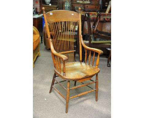 An oak open arm chair with stick back solid seat on turned legs