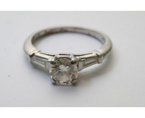 A quality platinum ladies ring, the central diamond .85 - 0.90ct graded colour of E/F and clarity VS. A central diamond flank