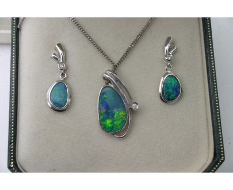 An opal and diamond pendant set in 14k white gold