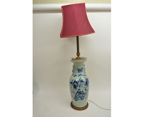 An Oriental blue and white vase converted in to table lamp and depicting figures in a garden setting, 124cm with shade.