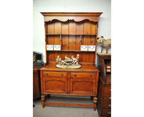 A stained pine dresser fitted with two drawers over two cupboard doors and having four blue and white ceramic storage drawers