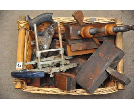 A basket of various tools including wood planes.