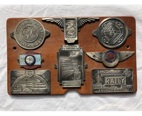 A group of assorted badges mounted on a plaque including Hastings, Blackpool Rallies, Royal Automobile Club etc. mostly late 
