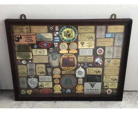 A framed and glazed collection of badges to include Junior Car Club, Northampton Motorcyclist's Club and Brooklands Automobil