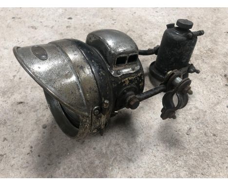 A vintage motorcycle headlamp and generator set. 
