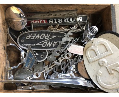 A box of car insignia, radiator badges including Land-Rover, Rover and Vauxhall etc. 