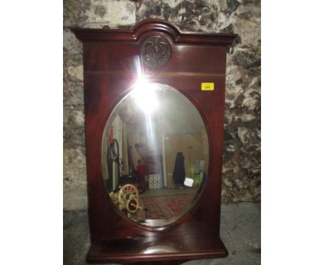 A mahogany framed wall mirror with shelf and carved motifLocation: 