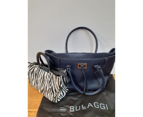 Bulaggi- Two modern bags, one in a zebra print with black resin handles and red interior having 2 zipped compartments and the