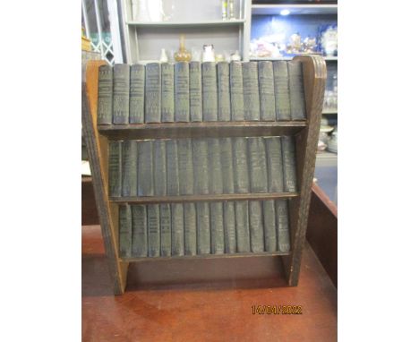 A set of forty miniature Shakespeare books published by Allied Newspapers Ltd on a miniature wooden open three shelf bookcase