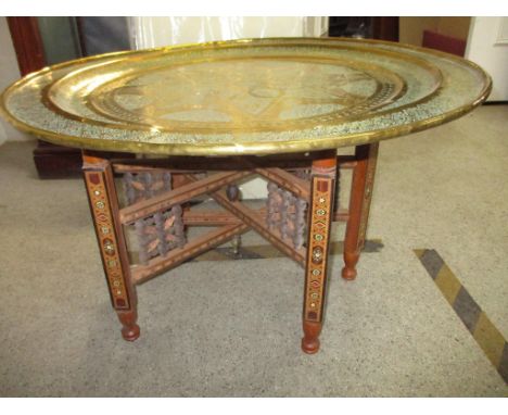 A four fold raw silk and cotton covered screen along with a North African inlaid folding wooden table with a brass tray topLo