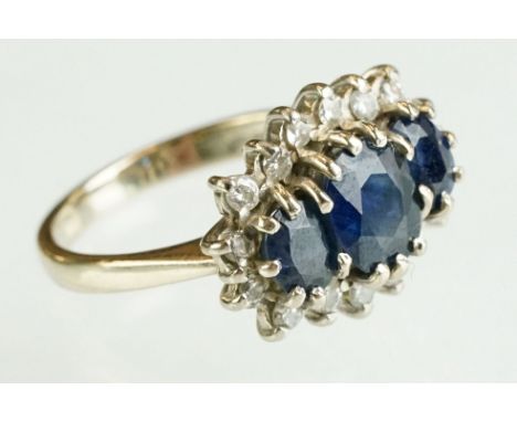 Sapphire and diamond 18ct yellow and white gold set cluster ring, three graduated mixed cut oval green-blue sapphires, the pr
