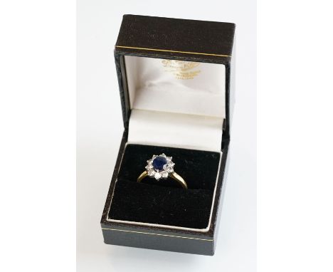 Sapphire and diamond 18ct yellow and white gold set cluster ring, the oval mixed cut sapphire measuring approx 7.5mm x 6mm, t