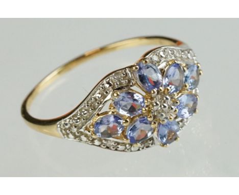 Iolite and diamond 14ct yellow and white gold ring, flower head design to centre, illusion set diamond surround, ring size V½