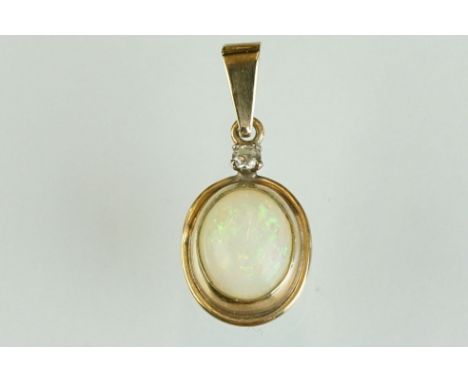 Opal and white stone yellow metal pendant, the oval cabochon cut precious white opal displaying blue, green yellow, orange an