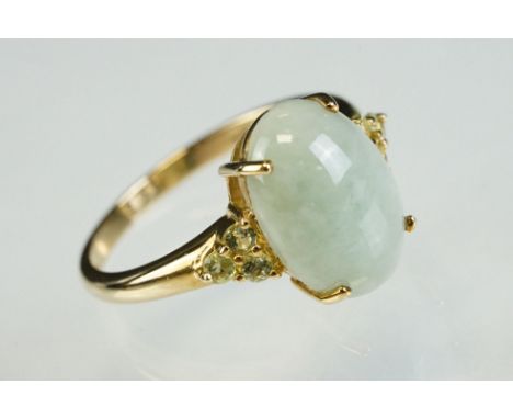 Jade 9ct yellow gold ring, oval cabochon cut jade measuring approx 14mm x 10mm, four claw setting, three small pale green sto