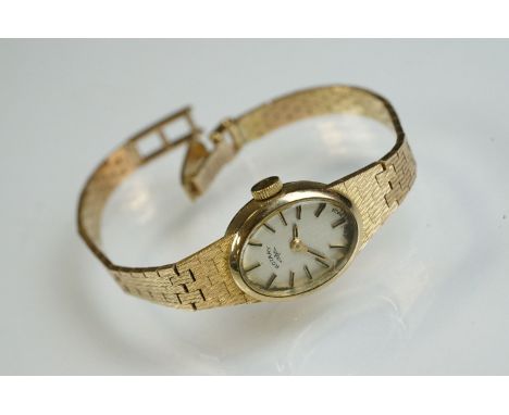 Rotary 9ct yellow gold ladies wristwatch, oval champagne dial, black enamelled gilt baton numerals and pencil hands, integral