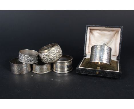 Six silver napkin rings, one with ornate Celtic design, one in a box