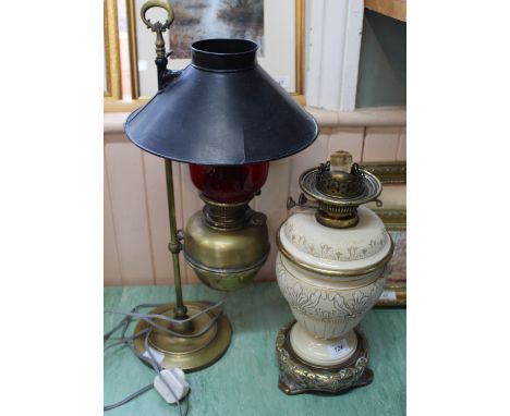 A Doulton style cream glazed urn form oil lamp with integrated reservoir, foliate design and brass base (no shade or chimney)