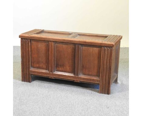 An early 20th century oak coffer, of panelled construction, with a hinged lid, containing a small collection of prints96w x 3