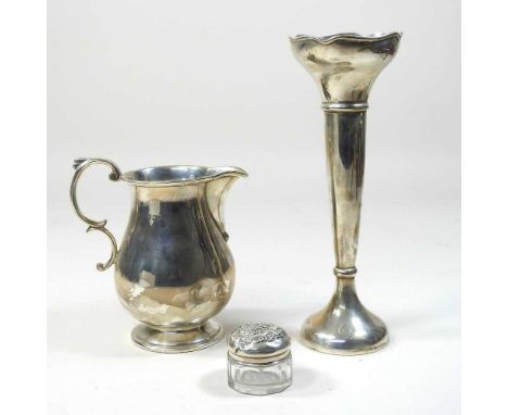 An early 20th century silver cream jug, London 1927, 194g, 12cm high, together with a silver spill vase and a glass trinket j