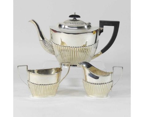 A modern silver three piece tea service, with half gardooned decoration, comprising a teapot, cream jug and sugar bowl, 894g 