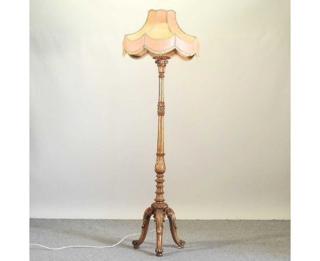 A carved and gilt painted standard lamp, with shade, 187cm high