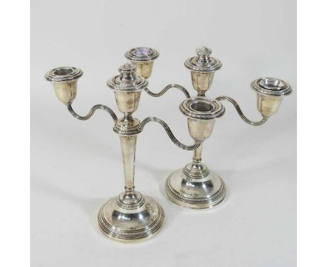 A pair of silver two branch table candelabra, with weighted bases, Birmingham 1957, 23cm high (2)Condition report: Appear com