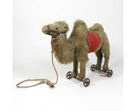 An early 20th century Steiff plush child's pull along toy Baktrian camel, on metal wheels, 22cm high. Thought to have been gi