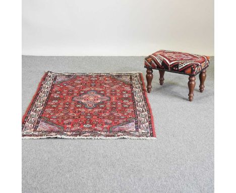 A kelim upholstered stool, together with a Persian rug, on a red ground, 162 x 106cm (2)Condition report: Stool looks modern 