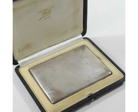 An early 20th century silver cigarette case, with engine turned decoration, London 1935, 144g, 12 x 8cm, in a leather present