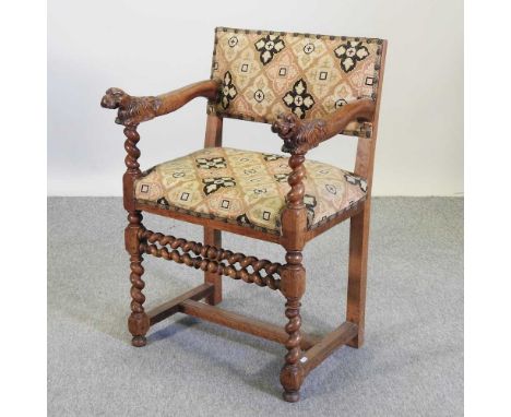 An early 20th century carved walnut open armchair, with a tapestry seat and back and lions mask terminals, on spirally turned