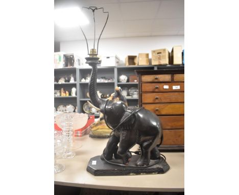An Art Deco era table top lamp in the form of an elephant in carved wood