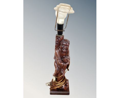 A Chinese carved hardwood figural table lamp in the form of a man holding a Koi fish, height 56 cm 