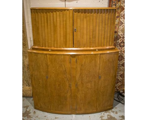 ART DECO COCKTAIL CABINET, walnut bow fronted with a pair of ripple panelled doors enclosing fitted interior above pull out m