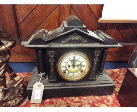A Victorian slate mantle clock of architectural form with brass bezel, the enamel dial and Roman numerals flanked by fluted c
