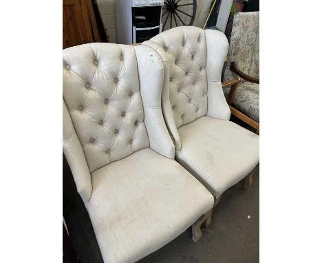 A pair of cream upholstered button backed chairs on cabriole legs