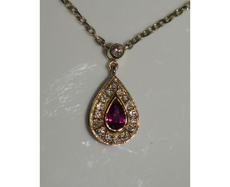 An 18ct Yellow Gold, Ruby and Diamond Pear Shaped Pendant on integral 15.5" chain, set with a central pear cut .22ct ruby sur