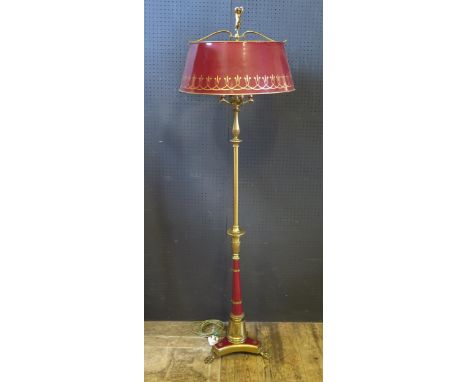 A Brass and Red Painted Standard Lamp with putto finial and standing on a lion paw tripod base, 169cm 