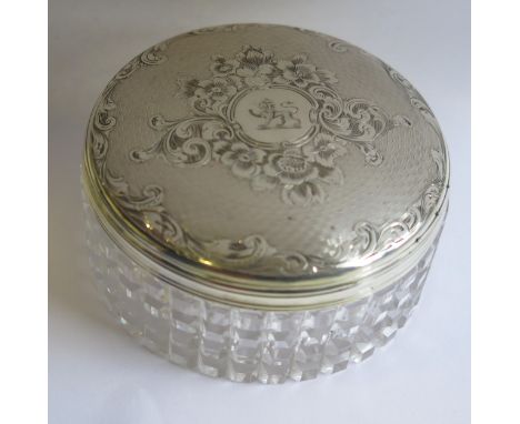 A Victorian Silver Top Cut Crystal Dressing Table Pot with engine turned and chased foliate scroll decoration and lion crest,