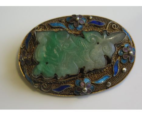 A Chinese Carved Jadeite Brooch in a silver gilt and enamel setting, 42x29mm 