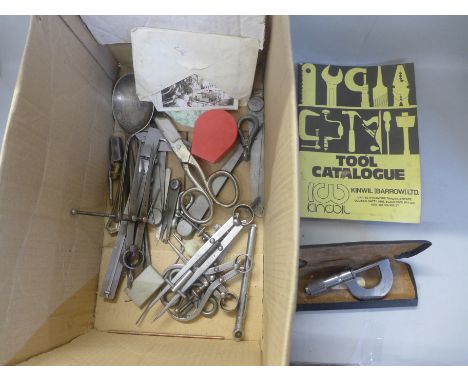 A collection of engineer's tools, calipers, etc., a large pair of scissors and black and white photographs of engineering tes